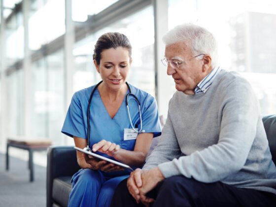 Nurse reviewing a tablet with an older patient